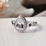 close up of aquamarine blue sapphire and moissanite halo ring in rhodium over sterling silver