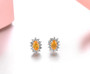 close up of spessartine garnet and white zircon oval halo studs in rhodium over sterling silver