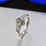 green sapphire and white zircon halo split shank ring in rhodium over sterling silver shown in a lifestyle photo