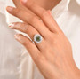 green sapphire and moissanite pear double halo ring in rhodium over sterling silver worn on a hand
