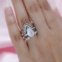 rainbow moonstone and moissanite pear four ring set in rhodium over sterling silver on hand model