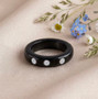 lab diamond in black jade band three stone ring shown in a lifestyle photo