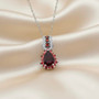 rhodolite red sapphire and zircon halo pendant necklace in rhodium over sterling silver shown in a lifestyle photo