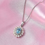 blue zircon freshwater pearl and moissanite double halo pendant necklace in rhodium over sterling silver shown in a lifestyle photo