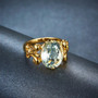 side view of prasiolite oval fleur-de-lis ring in 18k yellow gold over sterling silver