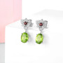peridot garnet and white zircon dangle earrings in rhodium over sterling silver shown in a lifestyle photo
