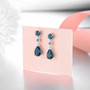 close up of sky swiss or london blue topaz dangle earrings in rhodium over sterling silver