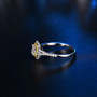 close up of emerald cut diamond and yellow diamonds halo ring in 14k white gold