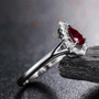 side view of ruby and diamond pear shape halo ring in 18k white gold