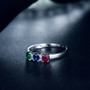 close up of emerald sapphire ruby and diamond trilogy ring in 14k white gold