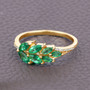 zambian emerald green gemstone ring in solid 14k yellow gold on fabric