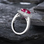 close up of lab ruby and diamond halo ring in 18k white gold