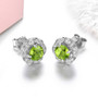side view of peridot and white zircon halo earrings in rhodium over sterling silver