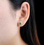 peridot and white zircon halo earrings in rhodium over sterling silver worn on the ear