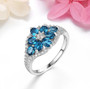 electric swiss blue topaz and zircon flower cluster ring in rhodium over sterling silver shown in a lifestyle photo