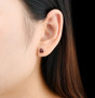 6mm trillion garnet stud earrings in rhodium over sterling silver worn on the ear
