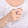 pink tourmaline and diamond emerald cut halo ring in 14k white gold worn on a hand