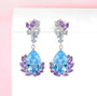 blue topaz and amethyst drop earrings in rhodium over sterling silver shown in a lifestyle photo