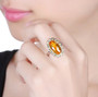 citrine and yellow sapphire 14k white gold halo cocktail ring worn on a hand