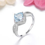 aquamarine and white zircon cushion halo ring in rhodium over sterling silver shown in a lifestyle photo