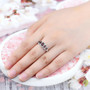 garnet and white zircon 5 stone band ring in rhodium over sterling silver worn on a hand
