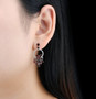 elegant garnet and white zircon articulating earrings in rhodium over sterling silver worn on the ear