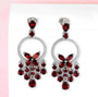 elegant garnet and white zircon articulating earrings in rhodium over sterling silver shown in a lifestyle photo