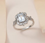 vintage inspired aquamarine and white zircon halo ring in rhodium over sterling silver shown in a lifestyle photo
