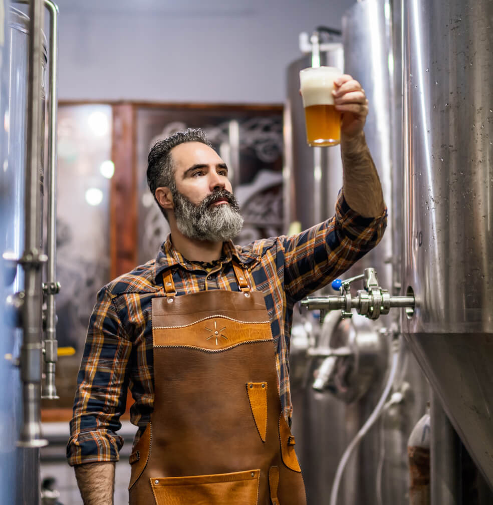 Man inspecting freshly brewed beer