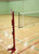 Floor fixed competition volleyball posts with net in use inside a sports hall