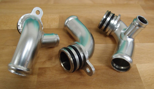 This set of stainless steel coolant pipes replaces the weak factory plastic units that are prone to failures.

This item is considered preventative maintenance and should be installed on all 997 Turbo (2007-2009), 997 GT2 (2008) and 997 GT2RS models. This part is not required or compatible with 996 Turbo models (which already have a metal tube).

A known weakness of the GT1 engine is that the coolant pipes (6-8 per engine) come unstuck from various housings and cause complete catastrophic coolant failures.

A lesser known issue involves the plastic coolant elbow pipes that run to the two oil coolers (aka heat exchangers). These pipes are molded plastic and have a very thin wall where the pipe connects to the engine with an O-ring seal. The problem is that over time and mileage, the thin plastic wall will break down at the o-ring slot (its weakest and thinnest point) causing a crack to appear. Eventually the whole engine will need to be removed in order to replace a cheap plastic tube. Both of these issues have been observed on the 997 GT3 and GT3RS as well.

After a customer spent nearly $2500 replacing this small part due to a coolant leak, costing him two track days and several weeks of downtime, we decided that a permanent solution was necessary and made these stainless steel pipes with CNC billet ends. We believe these should be used in place of the OEM part to avoid the aforementioned costs involved in replacing these leaky tubes ever again.
A razor blade showing where the stock piece fails. The car had approximately 40,000 miles of use in a mild climate:
The engine must be removed in order to install these so we recommend performing the "coolant fix" at the same time or replacing these whenever an engine rebuild is in progress.

Price shown is for the complete set of three pieces. O-rings are included and pre-installed. Made in California from stainless steel.
