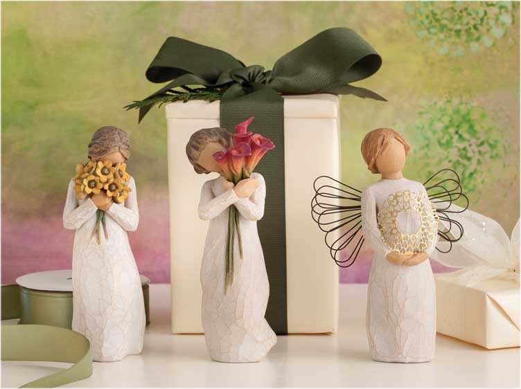 Hand-carved figurines in front of a wrapped gift box