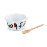 A white appetizer bowl with several little birds painted on the front. Placed beside a wooden spoon.