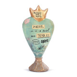 A blue heart sculpture with a golden crown. Reads "pause rest and tend to your spirit".