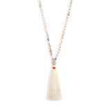 A simple ivory and red necklace with various beads and an ivory tassle.