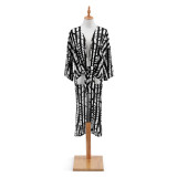 A black and white patterned Tie Front Duster. Placed on a white and black metal mannequin.