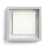 A gray frame enclosing a cream ceramic plate with an ocean scene engraved.