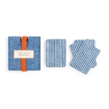 Two piles of blue and white striped playing cards placed to the right of a soft blue felt card holder, with an orange ribbon and a white patch that reads deal me in playing cards"."