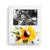 A white ceramic picture frame with a large watercolor painted sunflower on the bottom.