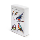 A side view of a white ceramic plaque with five painted birds on tree branches and "be kind to every little thing" in black cursive font.
