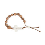 A brown corded boy's rosary bracelet with several wooden beads, and a cream cross with Luke 22:19" engraved."
