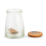 A round glass container with a wood lid that says "Dear Baby" off and to the side. There are paper messages inside the jar.