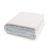 A cream and blue ombre knit blanket folded and set against a white background.