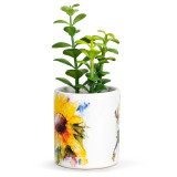 A white ceramic planter with an image of a watercolor sunflower. The planter has a fake green succulent inside, displayed angled to the left.