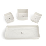 Four white ceramic serving dishes, three are square and one is rectangular and they are labeled a through d set apart from each other.