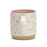 Side view of the handle of a cream mug that says "The Very Best Nana" in brown with dots and hearts.
