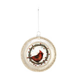 A globe shaped glass and gold glitter ornament, with an image of a red cardinal sitting in a wreath in the center.