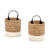 A set of two round brown woven baskets with a black handle and cream fabric base.
