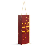 A lit wood holiday lantern with dark red front that says "May Your Nights Be Bubbly and Bright" with a rope handle at the top, displayed angled to the right.