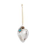 Blown glass silver heart shaped ornament with a silver snowflake token attached with a blue stone in the center for December, displayed angled to the left.